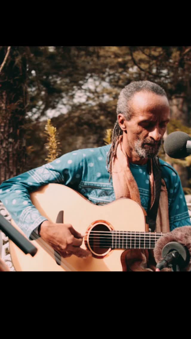 Leal cantando ao microfone com violão, na Udiyana Bandha
